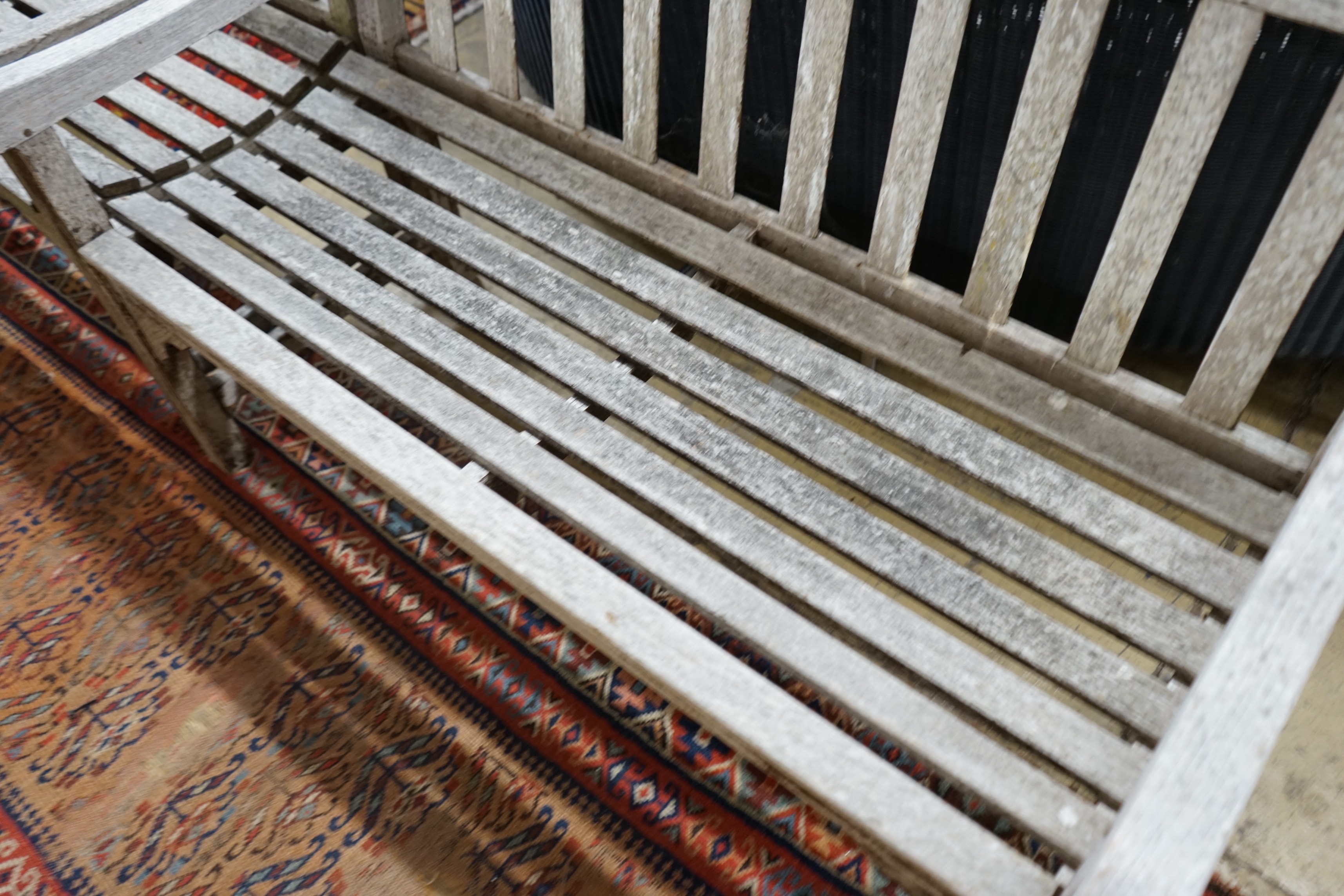 A pair of weathered teak slatted garden benches, each length 121cm, depth 56cm, height 85cm